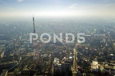 Aerial view of modern city urban foggy landscape with tall television tower o Stock Photos