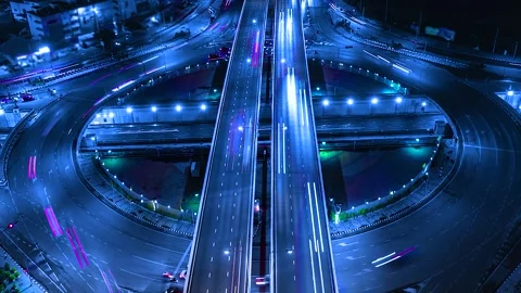 Aerial view of a modern highway interchange with light trails at night Vidéo 344167958