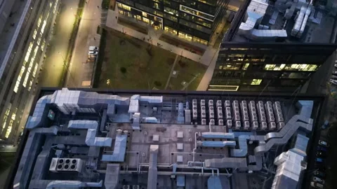 Aerial view of modern office building rooftops at evening time, showcasing Stock Footage 335885122