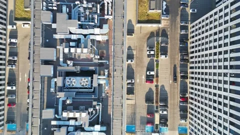 Aerial view of modern office building rooftops transitioning to parking lot Stock Footage 335886772