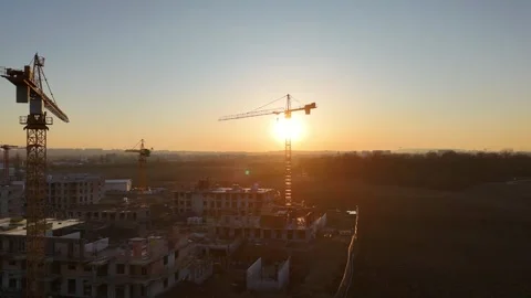 Aerial view of modern residential complex construction with cranes at sunset Stock Footage 335884670