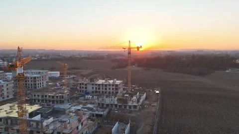 Aerial view of modern residential complex construction with cranes at sunset Stock Footage 335884739