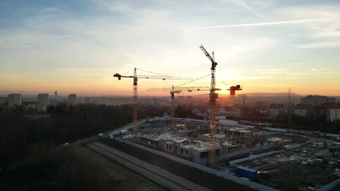 Aerial view of modern residential complex construction with cranes at sunset Stock Footage 335885059