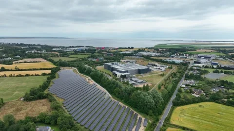 Aerial view a modern solar farm beside a food processing planting County Stock Footage 341353353
