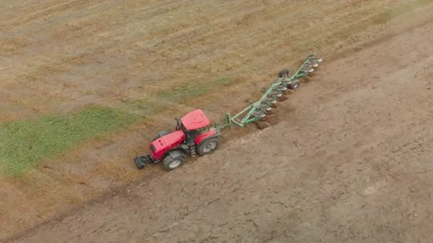 Aerial view: modern tractor on arable land, cultivating fertile farmland in Stock Footage 142555668