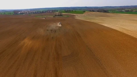 Aerial view of a modern tractor plowing a dry field in spring Stock Footage 88779711