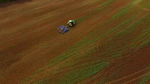 Aerial view of a modern tractor plowing a dry field in spring Stock Footage 89319057