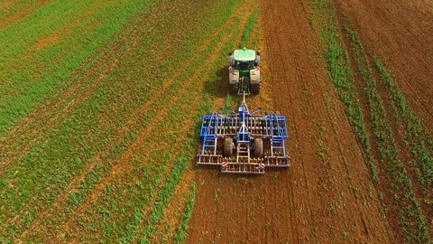 Aerial view of a modern tractor plowing a dry field in spring Stock Footage 89321105