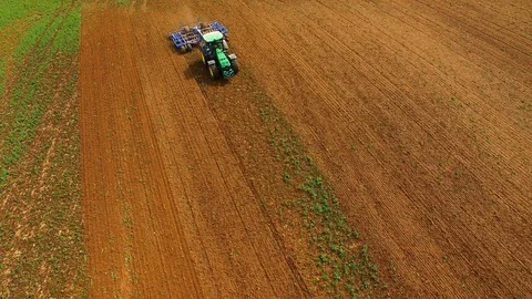 Aerial view of a modern tractor plowing a dry field in spring Stock Footage 89321491
