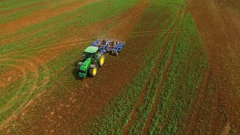 Aerial view of a modern tractor plowing a dry field in spring Stock Footage 89324370