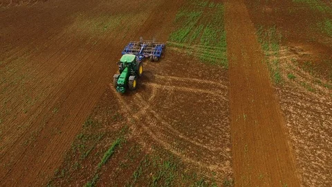 Aerial view of a modern tractor plowing a dry field in spring Stock Footage 89343850