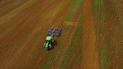 Aerial view of a modern tractor plowing a dry field in spring Stock Footage 89345711