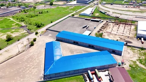 Aerial View of Modern Warehouse Complex with Blue Roofs and Large Logistics Yard Stock Footage 340041503