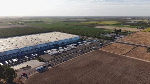 Aerial View of Modern Warehouse Logistics and Distribution Center in Farmland Stock Footage 345802226