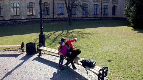 Aerial view of mom with kid taking selfie on phone in park bench. Mom with child Stock Footage 158097070