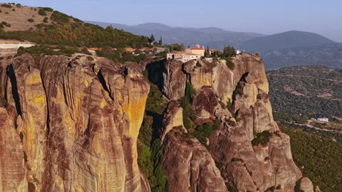 Aerial view of monasteries atop cliffs in Greece at sunset Stock Footage 294784580