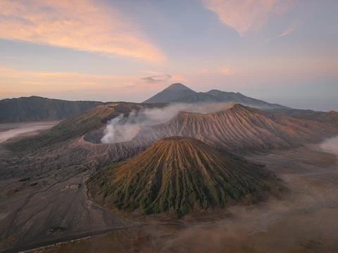 Aerial view of Mount Bromo piercing through a sea of swirling clouds under .. 스톡 사진