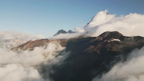 Aerial view of Mount Ushba peak partially covered in morning clouds. A dram.. Stock-Footage 332264424
