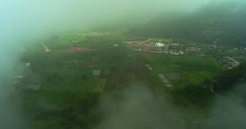 Aerial view of mountain cliff emerging through thick fog and clouds Stock-Footage 333407622