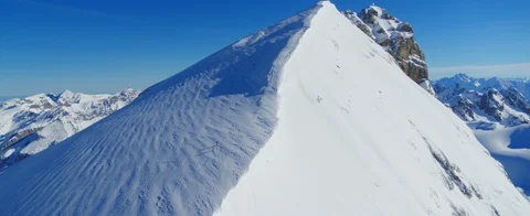 Aerial view of Mountain climber. Two people climing a pyramid shaped mountain  Stock Footage 121482195