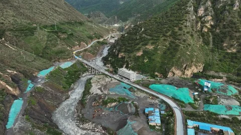 Aerial view of mountain construction site beside rocky river valley in Daocheng Vídeos de archivo 336664807
