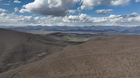 Aerial View of Mountain Forest Landscape Under Blue Sky with White Clouds Video stock 332186870