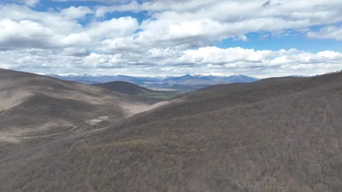 Aerial View of Mountain Forest Landscape Under Blue Sky with White Clouds Video stock 332200409