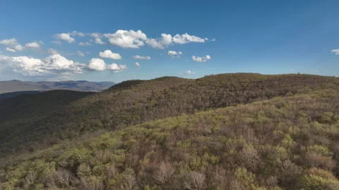 Aerial View of Mountain Forest Landscape Under Blue Sky with White Clouds Video stock 332249101