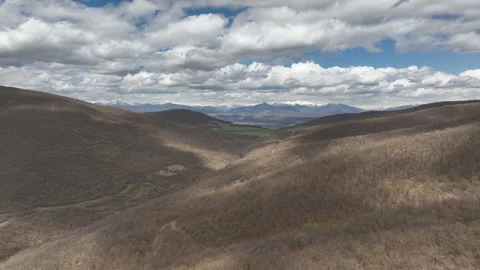 Aerial View of Mountain Forest Landscape Under Blue Sky with White Clouds Video stock 332249231