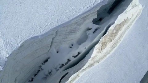 Aerial view of the mountain glacier crevasse with ice fracture covered in snow. Stock Footage