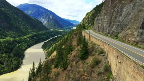 Aerial view of a mountain highway along a winding river gorge in daylight Stock Footage 343543443