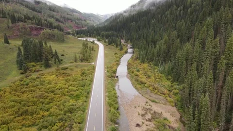 Aerial view of mountain highway with river on the right Stock Footage 336504762