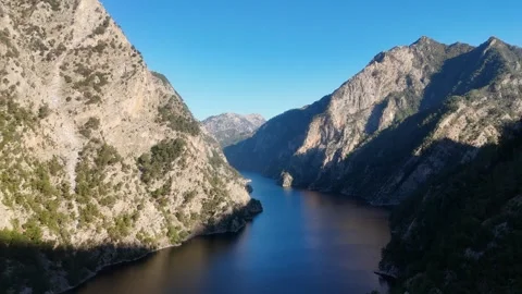 Aerial View of Mountain Lake Between Steep Rocky Cliffs Stock Footage 324042457