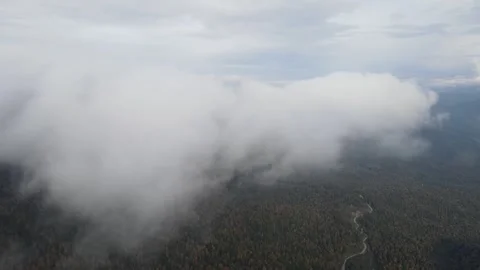 Aerial view of mountain landscape with clouds and winding road. Stock Footage 337890115