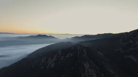 Aerial view of a mountain landscape with a dense forest covered by a dense veil Video stock 126678552