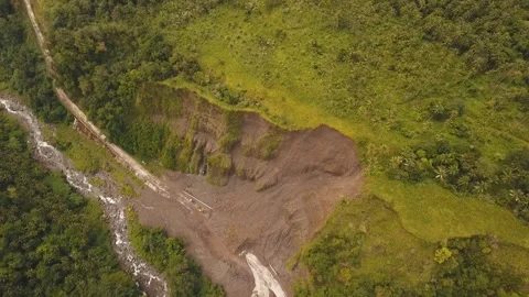 Aerial view of a mountain landslide blocking a rural road near a river Stock Footage 342266058