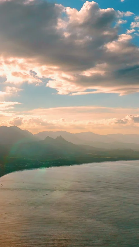 Aerial view of mountain range and bay at golden hour. Vertical video. Stock Footage 328931442