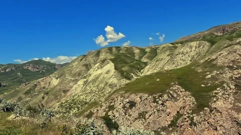 Aerial view of a mountain range with blue sky and white clouds Stock-Footage 317386980