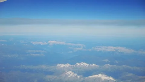 Aerial view of mountain range covered in snow, seen from an airplane in 4K .. Stock Footage 286299340