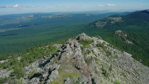 Aerial view of mountain range with pano of overgrown slopes and stone peaks Stock Footage 138006057