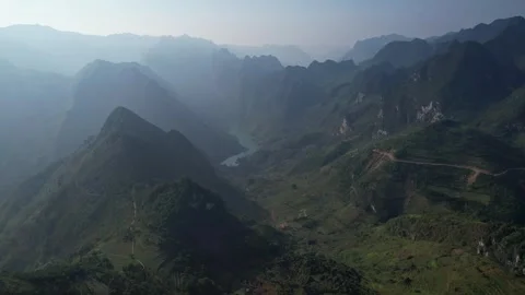 Aerial view of mountain range with river, under beautiful sky Ha Giang Loop Stock Footage 277592140