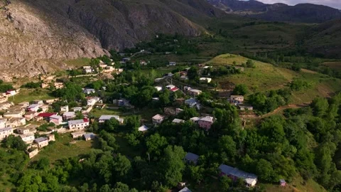 Aerial view mountain range with a small village in the valley Stock Footage 327962990