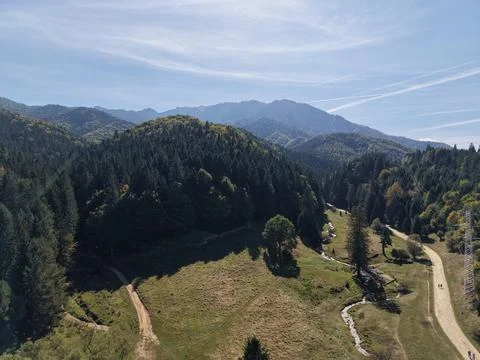 Aerial view of mountain range valley with forest and stream Stock Photos