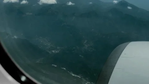 Aerial View of Mountain Ranges and Jet Engine from Airplane Window Stock Footage 337947568