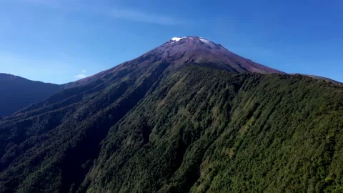 Aerial view of a mountain rigde full of trees leading to the Tungurahua volcano Stock Footage 236777529