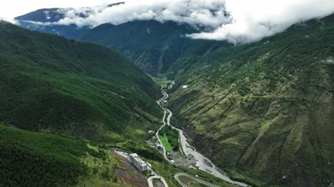Aerial view of mountain river flowing at the bottom of steep deep green valley Stock Footage 336698153