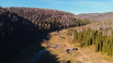 Aerial view of a mountain river surrounded by mountains with coniferous trees Stock Footage 106275975