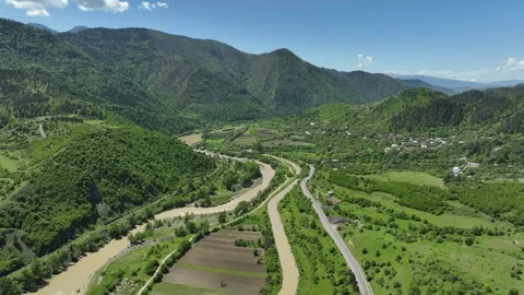 Aerial view of mountain river valley with winding road and green hills in summer Stock-Footage 331121332