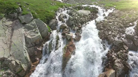Aerial view to the mountain river which falling down from cliff like waterfall Stock Footage 203587523