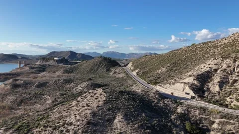 Aerial View of Mountain Road and Reservoir in a Dry Landscape Stock Footage 346414311